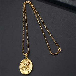Macro view of gold stainless steel Jesus pendant and round box chain on grey background