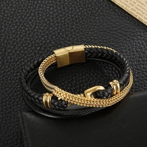 Detail of multi-layer men's leather bracelet with gold magnetic clasp and black braided rope
