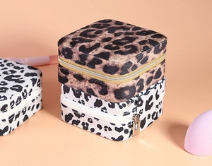 Detail of square leopard print jewelry boxes with velvet texture and zipper closure