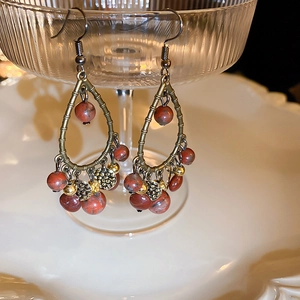 Detailed close-up of vintage bronze waterdrop earrings with reddish-brown marble beads