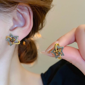 Detail of vintage gold Saturn earrings featuring black crystals on a model's ear