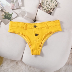 Détails du mini short en jean jaune vif avec boutons métalliques sur canapé blanc