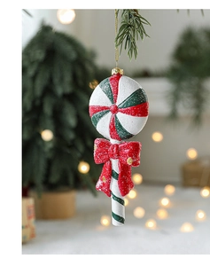Close-up of a red and white candy cane ornament with a red bow hanging on a Christmas tree