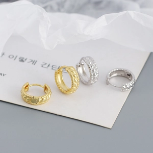 Detail of twisted s925 silver hoop earrings in gold and silver finish on display card