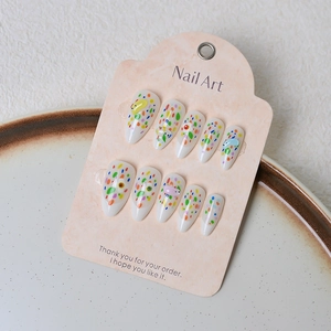 Almond press-on nails with colorful polka dots and 3D bear resin charms on pink card