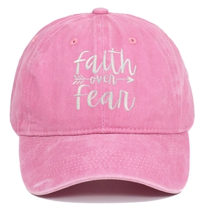 Close-up of Faith Over Fear white embroidery on pink washed cotton baseball cap texture