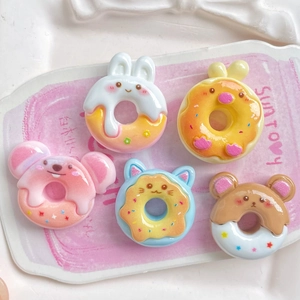 Close-up of cute cartoon animal resin donut charms including bunny bear and chick figures