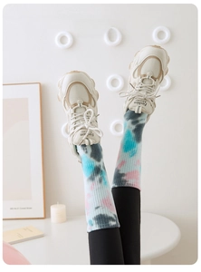 Tie-dye yoga socks paired with retro chunky sneakers in a cozy home setting