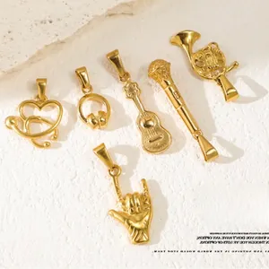 Detail of six gold-plated music pendants including guitar and headphones on stone