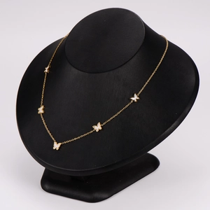 Elegant gold butterfly necklace with five white pendants on black mannequin stand