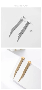 Detail of long tassel earrings in gold and silver finish with semi-circle metal studs