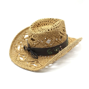 Detail of hollow woven straw cowboy hat featuring floral embroidery on a brown band