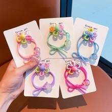 Detail of five candy-colored seamless hair ties with floral charms and beads on cards