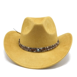 Detail of yellow suede cowboy hat with braided band and evil eye charm embellishment