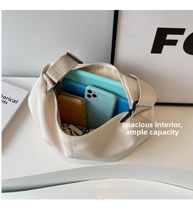 Close-up of large capacity crescent tote bag showing spacious interior with tablet and phone