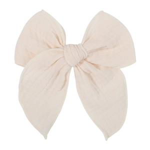 Detailed macro view of beige jacquard cotton bow hair clip showing textured fabric