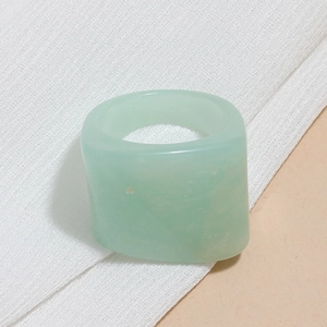 Detail of a minimalist light green resin ring with a smooth translucent finish