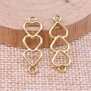 Three-heart hollow link charms in gold finish for DIY jewelry making on wooden base