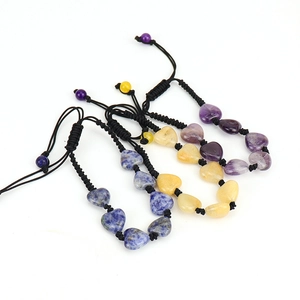 Close-up of hand-woven heart-shaped natural crystal bracelets in blue, yellow and purple