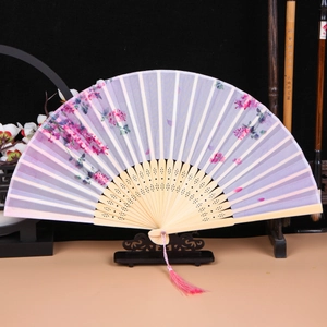 Detailed view of a Chinese folding fan with silk floral fabric and carved bamboo ribs