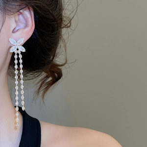 Macro detail of silver-plated butterfly earrings with long zirconia tassel fringes