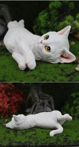 Detailed macro view of white resin cat figurine with realistic fur texture for garden decor