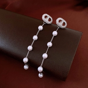 Detailed view of silver tassel earrings with white pearls and luxury crystal design