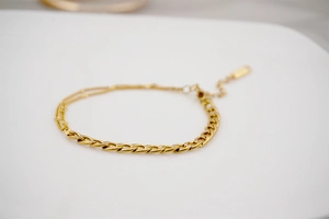 Detail of gold Cuban and double parallel thin chain bracelet with lobster clasp