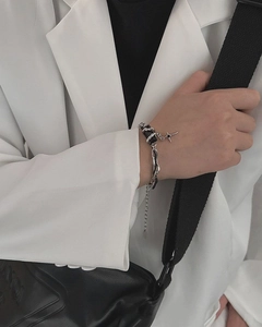 Detail of titanium steel star charm bracelet worn on wrist with black and white suit