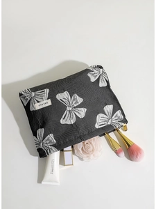 Borsa cosmetica nera estetica scura con motivo a fiocco bianco e accessori trucco