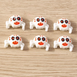 Detail of six white spider charms with red and black accents for Halloween DIY crafts