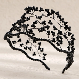 Macro detail of hand-woven black crystal beads and branch pattern on the bridal crown