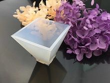 Translucent white pyramid silicone mold for resin art casting on black surface