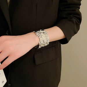 Detail view of the silver crumpled metal texture on a wide-style geometric cuff bracelet