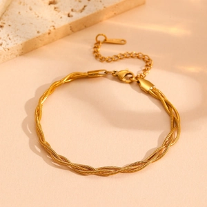 Detailed close-up of a gold multi-strand braided snake chain bracelet with lobster clasp
