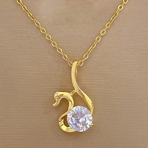 Macro shot of gold swan pendant necklace featuring a large sparkling cubic zirconia crystal