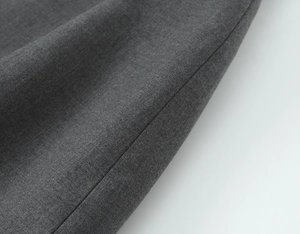 Vue macro détaillée montrant le tissu sergé gris foncé et les coutures de haute qualité