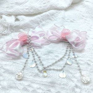 Détail de pinces à cheveux nśud sirène rose avec perles et coquillages sur dentelle