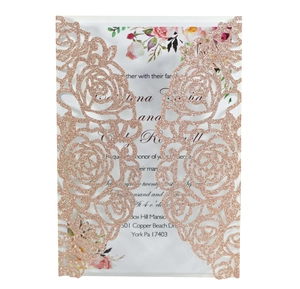 Macro shot of rose gold glitter laser-cut wedding invitation with elegant rose patterns