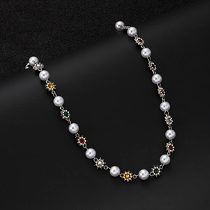 Detail of pearl necklace featuring rhinestone-encrusted colorful flower accents