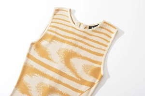 Dettaglio del top in maglia gialla con cerniera dorata e motivo jacquard astratto alla moda