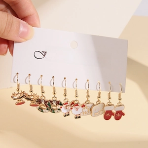 Close-up of five pairs of Christmas enamel earrings with reindeer and snowflake motifs