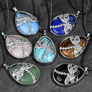 Close-up of teardrop stone pendants with dragonfly motif in seven vibrant colors