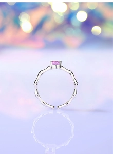Macro view of bamboo style silver ring featuring a vibrant square pink gemstone
