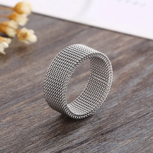 Detailed macro shot of a silver mesh grid textured stainless steel ring on wood