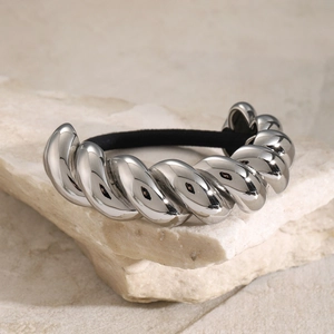 Polished silver metal spiral hair tie on a natural stone base with black elastic band