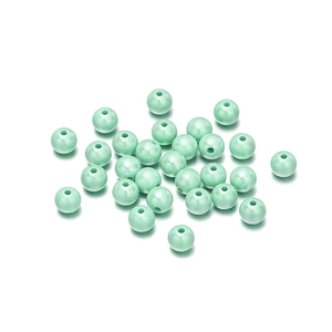 Macro detail of round light green acrylic beads with pearl finish for DIY jewelry