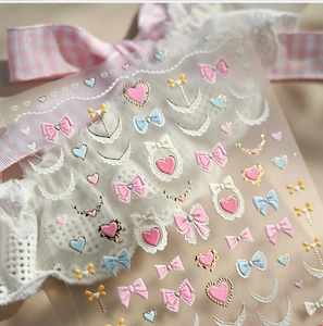 Détail de stickers à ongles kawaii en relief avec cœurs roses et nœuds en dentelle