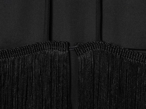 Detailaufnahme von Samtstoff mit Fransen an einem schwarzen Neckholder-Top