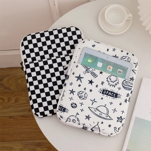 Detail of checkered and space graffiti laptop sleeves with front pockets on a white table